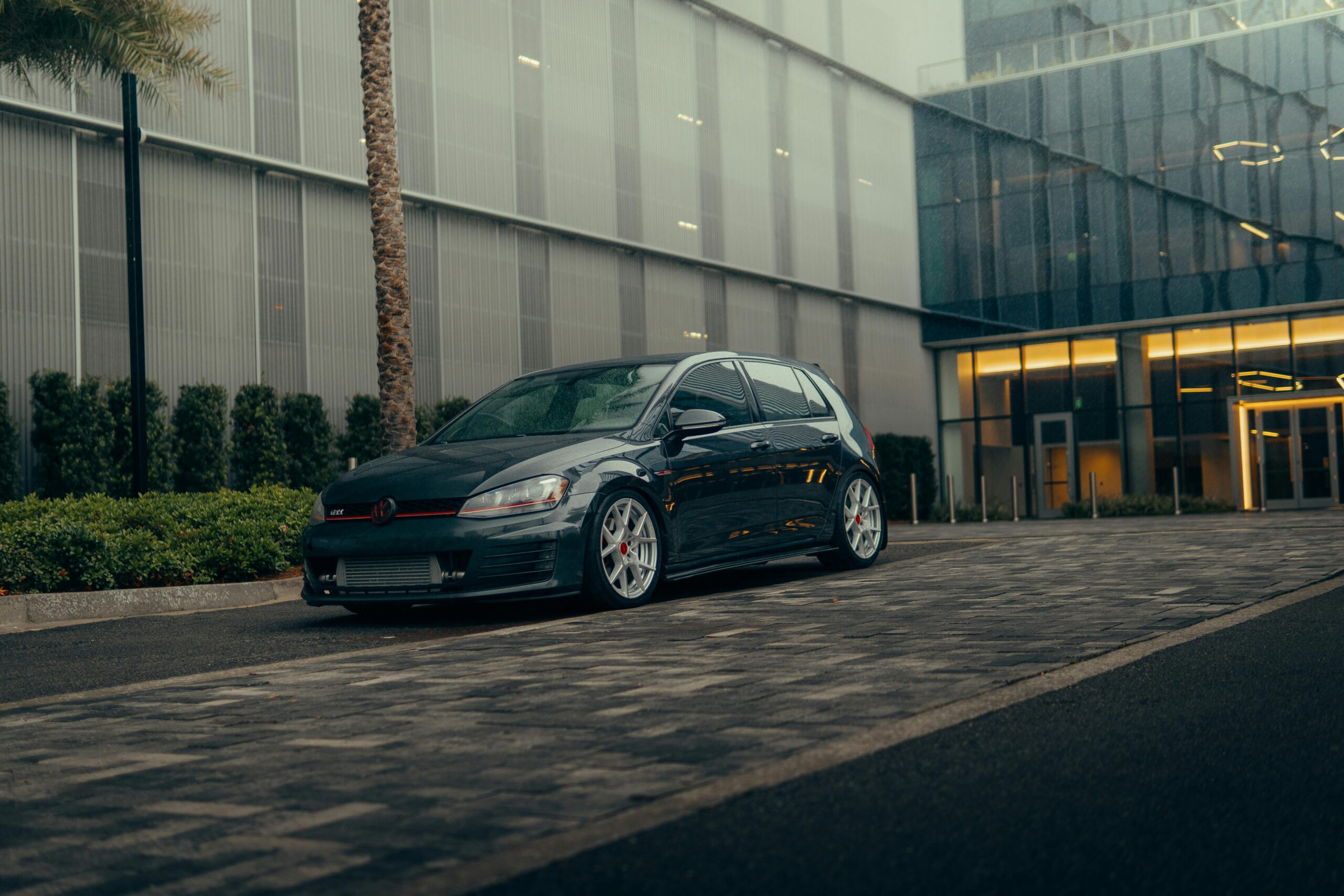 Volkswagen Golf GTI parked in a modern urban environment, showcasing its sporty design.